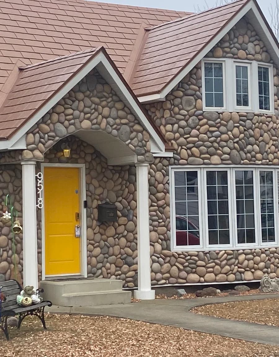River rock stone house with yellow door